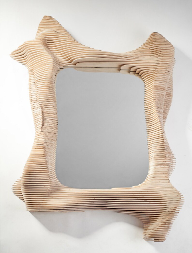 Puede incluir: Un espejo de madera con un marco &uacute;nico, org&aacute;nico y abstracto. El marco est&aacute; hecho de finas piezas de madera superpuestas que crean un dise&ntilde;o fluido y ondulado.