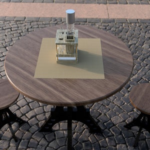 May include: A wooden table with a brown top and black metal legs. There are two matching wooden stools with black metal legs. A wooden stand with a clear glass bottle is on the table.