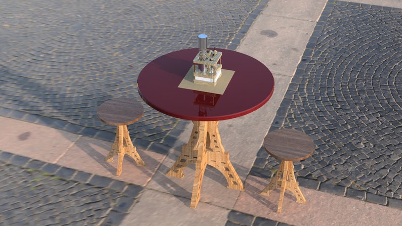 May include: A red round table with a gold metal object on top, and two wooden stools with Eiffel Tower-shaped legs. The table and stools are on a gray cobblestone surface.
