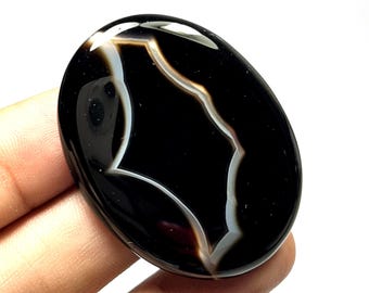 Cabochão de ágata preta listrada, gema oval em formato de pera.