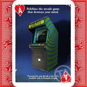 May include: An arcade game cabinet with the text "Polybius: the arcade game that destroys your mind." The cabinet is decorated in green, blue, and black, with a swirling pattern on the screen. The screen displays the word "START".