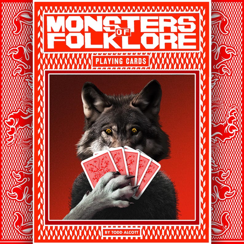 May include: A deck of "Monsters of Folklore" playing cards. The card box is red with white text and a white border. The image on the box features a wolf holding red playing cards. The text "PLAYING CARDS" is also visible.