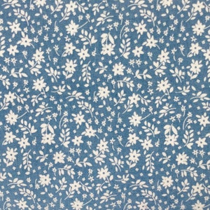 May include: A blue fabric with a white floral pattern. The pattern features small white flowers and leaves.