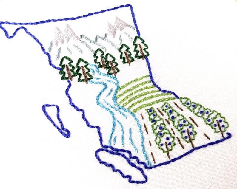 May include: Embroidered design of the Canadian province of British Columbia, featuring a blue outline of the province with mountains, a river, and trees in green and brown.