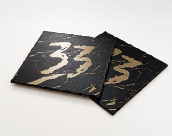 Posavasos acrílicos Clair Obscur Expedition 33 negros y dorados para taza o pulsera