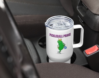 May include: White travel mug with a green pickle wearing a gold crown and holding a blue paddle. The text "Pickleball Prince" is printed on the mug.