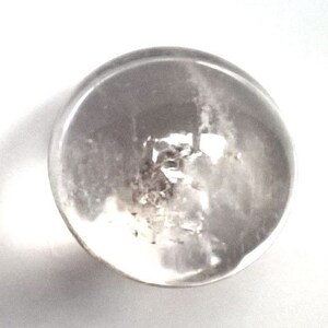 May include: A clear glass sphere with a cloudy, white interior. The sphere is smooth and reflective.