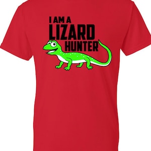 May include: Red t-shirt with a black graphic of a green lizard and the text "I am a lizard hunter".