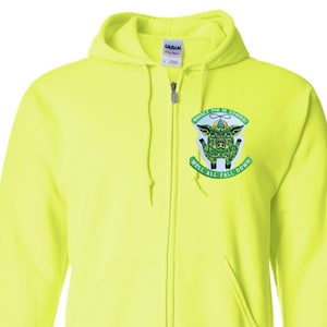 May include: Bright yellow zip-up hoodie with a drawstring hood and front pockets. The hoodie features a graphic on the left chest with a pig design and the text "Whirly Pig is Coming! Well All Fall Down."