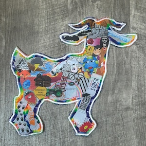 May include: A colorful goat-shaped collage with a rainbow outline. The collage is filled with various images, including a fox, a train, a cartoon earth, and the word "SOBER" on a license plate. The background is a wood grain.