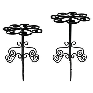 May include: Two black metal plant stands with a decorative scroll design. The stands have a circular top and a single central support post.