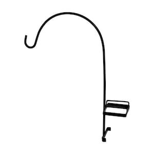 May include: Black metal plant stand with a curved arm and a small shelf. The stand is designed to hold a hanging plant.