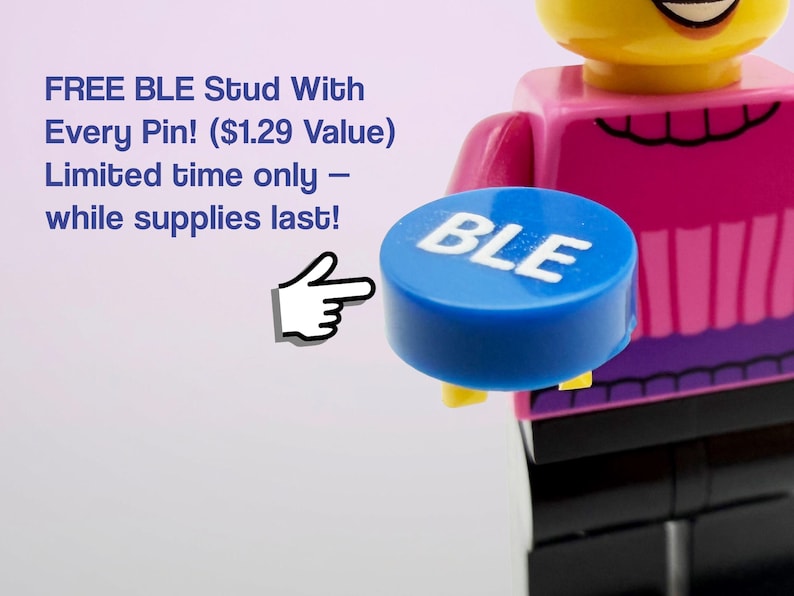May include: A blue circular stud with the white text BLE printed on the top surface. The stud is held by a yellow plastic figure wearing a pink shirt and black pants. A white hand icon points toward the blue stud, and text reads FREE BLE Stud With Every Pin! ($1.29 Value) Limited time only &ndash; while supplies last!