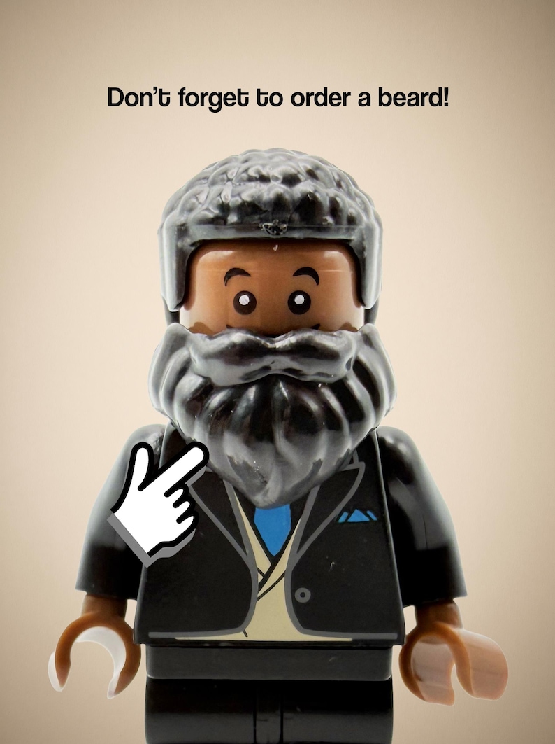 May include: A plastic minifigure with dark brown skin, a textured black hair piece, and a thick black beard. The figure wears a black suit jacket over a tan vest and a blue tie. Above the figure, the text reads: Don't forget to order a beard!