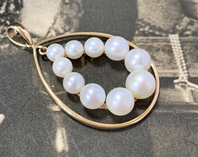 Vintage pearl pendant for a chain or strap. Crafted in 9ct yellow gold it features a remarkable design and beautiful pearls