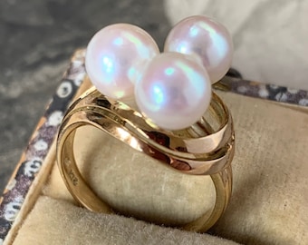 Mikimoto Pearl trilogy Ring. 14ct yellow Gold with three beautiful akoya pearls in a ribbon design. Ring size L.5 (UK)