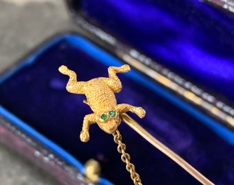 Beautiful yellow gold and emerald frog brooch or jabot pin. Finely textured details to its body with original antique box