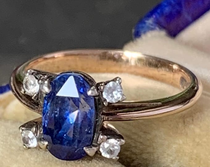 Oval cut ocean blue natural sapphire accented by white topaz on each side. 1930s 9ct yellow gold ring. Ring size M size 6 (US) 3.5 grams