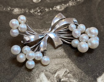Tasaki Akoya Pearl Brooch. Set in fine silver bow design and featuring a massive 21 stunning quality pearls