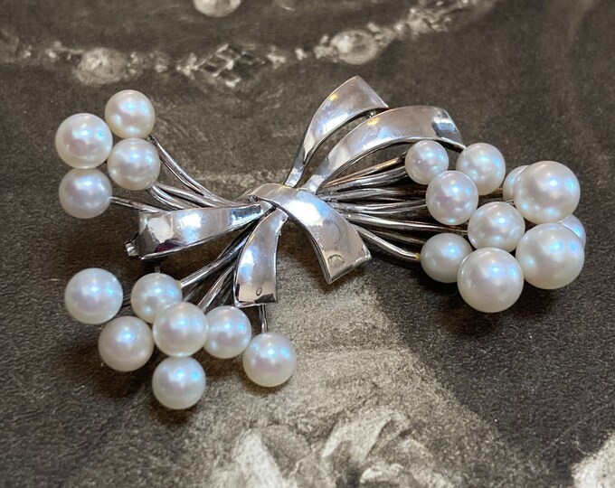 Tasaki Akoya Pearl Brooch. Set in fine silver bow design and featuring a massive 21 stunning quality pearls