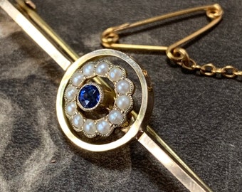 Art deco blue Sapphire and pearl brooch. 9ct yellow gold with open Halo target design that has 12 split pearls