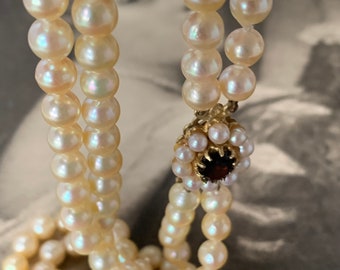 Double strand Akoya pearl necklace. 6.5mm Akoya pearls. Princess length with 9ct gold garnet and pearl clasp. Full English hallmarks