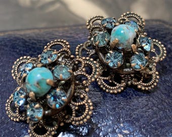 Edwardian clip on earrings set with paste aquamarine colour glass stones and a central turquoise gemstone. Filigree pressed metalwork