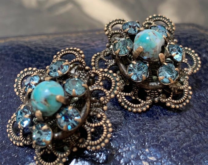 Edwardian clip on earrings set with paste aquamarine colour glass stones and a central turquoise gemstone. Filigree pressed metalwork