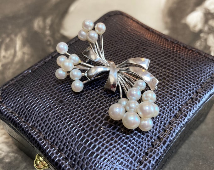 Vintage Tasaki Pearl Brooch. Set in fine silver bow design and featuring a massive 21 akoya quality 3.5mm-6mm pearls