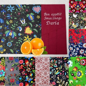 May include: A red placemat with a floral pattern and the text "Bon appétit Smacznego Daria". The placemat is surrounded by eight smaller placemats with different floral patterns.