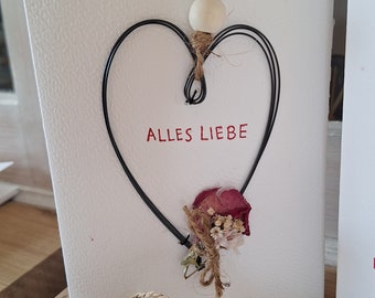 Frei von Hand geformte Herzen aus Draht auf einer Karte mit Trockenblumen als Karte oder Geschenkanhänger für einen Lieben Menschen Blumen