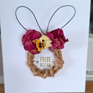 Frei Hand geformte Jute Eier mit Drahtohren und einer Schleife aus getrockneten Rosen mit Hornveilchen als Osterdekoration Ostergeschenk