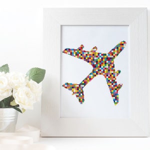 May include: A white framed print of a colorful airplane made of squares. The airplane is flying in the sky. The print is perfect for a child's room or a playroom.