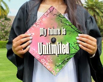 Op de afbeelding: Een roze en groene afstudeerhoed met een bloemenpatroon en de tekst "My future is Unlimited".