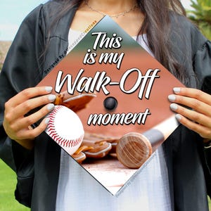 May include: A graduation cap with a baseball theme. The cap is decorated with a baseball, bat, glove, and the text "This is my Walk-Off moment".