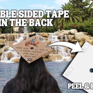 May include: A white peel and place sticker with double-sided tape on the back. The sticker has a round hole in the center. The text "PEEL & PLACE" is printed on the bottom of the sticker.