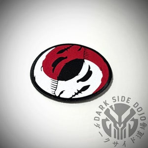 May include: A red and white yin yang symbol with a skull design. The symbol is embroidered on a black patch.