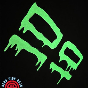 May include: Black t-shirt with a neon green graphic design. The design features four abstract shapes with a dripping effect. The words "DARK SIDE DOJO" are printed in a circular logo at the bottom left.