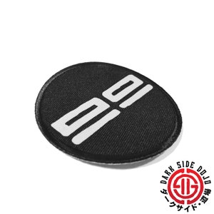 May include: A black circular patch with white text that reads "99".