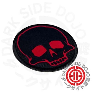 May include: Black and red embroidered skull patch. The skull is outlined in red and has red eyes.