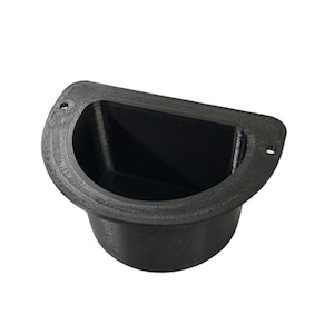 May include: A black plastic wall mount with a rounded, open-top container. The container has a smooth, slightly textured surface and two small holes on the sides.