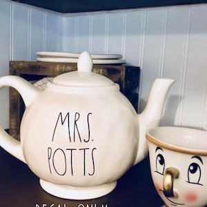 May include: Cream-colored teapot and teacup set with the text "MRS. POTTS" on the teapot. The teacup has a cartoon face design. The words "DECAL ONLY" are at the bottom of the image.
