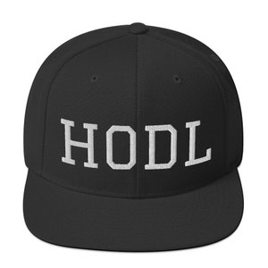 May include: Black and white baseball cap with the word "HODL" embroidered in white on the front.