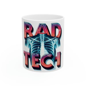 May include: White ceramic mug featuring a colourful graphic of an x-ray image of a human torso and the text "RAD TECH" in a retro style.