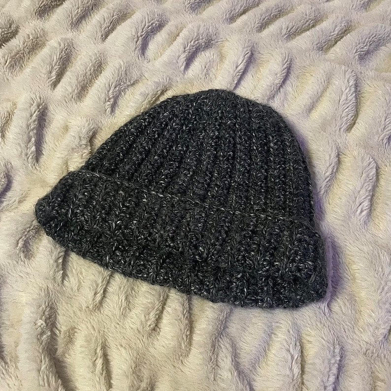 May include: A dark gray knitted beanie with a ribbed texture.
