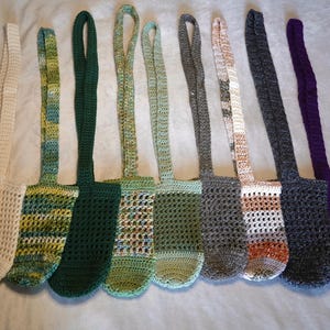 May include: Nine crocheted bags with different colored patterns. The bags are made with a variety of colors, including white, green, brown, and purple. The bags have a simple design and are perfect for carrying small items.