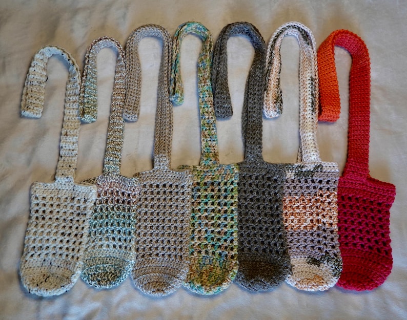 May include: Seven crocheted bottle holders with different colored yarn. The holders are made with a simple stitch pattern and have a long strap for carrying.