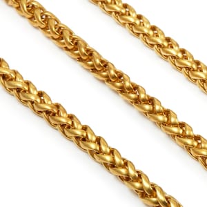 May include: Three gold chains with a braided design. The chains are arranged in a diagonal line on a white background.