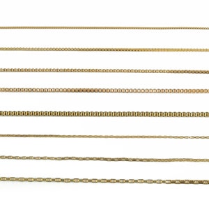 May include: A set of eight gold chains of varying lengths and thicknesses, displayed against a white background.