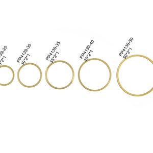 May include: A set of ten gold-colored metal rings of varying sizes. The rings are labeled with their diameter in inches and millimeters. The rings are arranged in order of size, from smallest to largest.